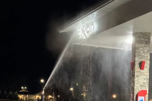 Washing Exxon sign at gas station from ground