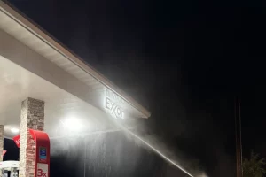 Washing Exxon sign at gas station night time