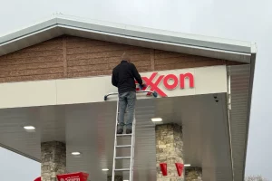 Washing Exxon sign at gas station